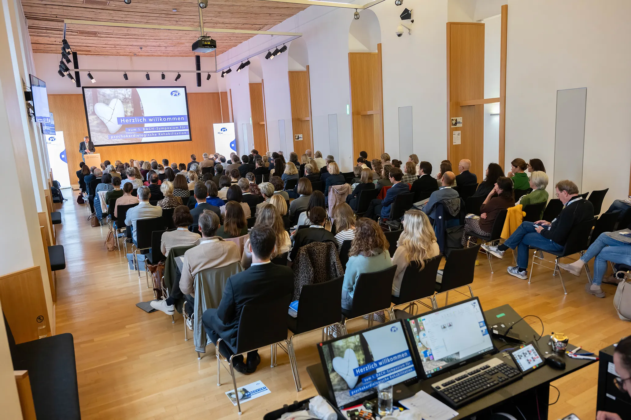 Blick von hinten über das Publikum auf das Podium