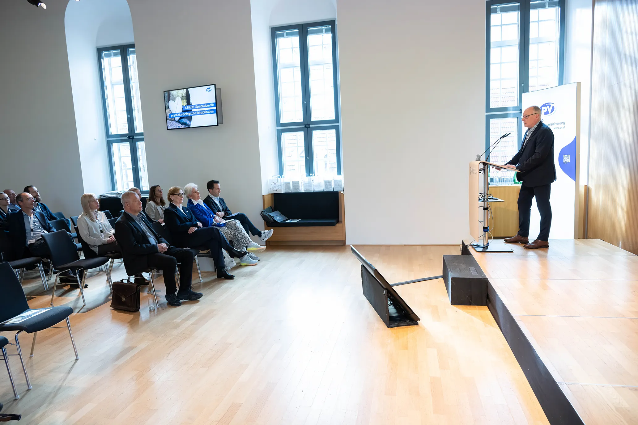 Dr. Eike Langheim am Podium vor Publikum