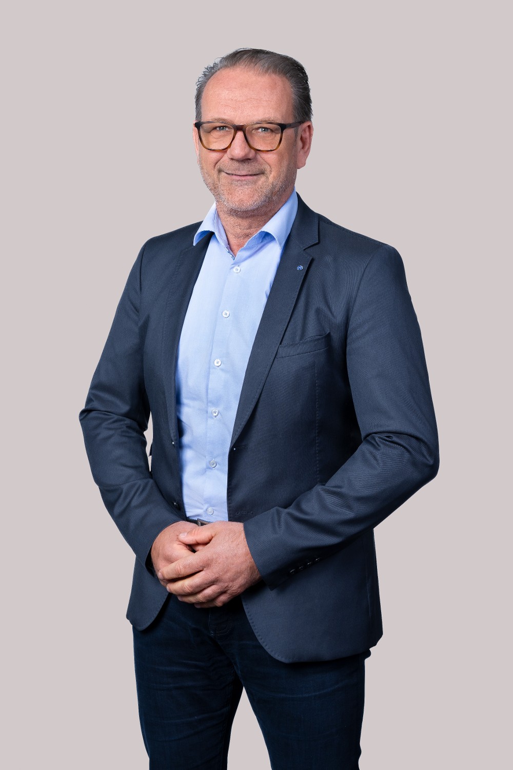 Porträt von Andreas Herz, Obmann der Pensionsversicherung, mit Brille und dunkelblauem Sakko
