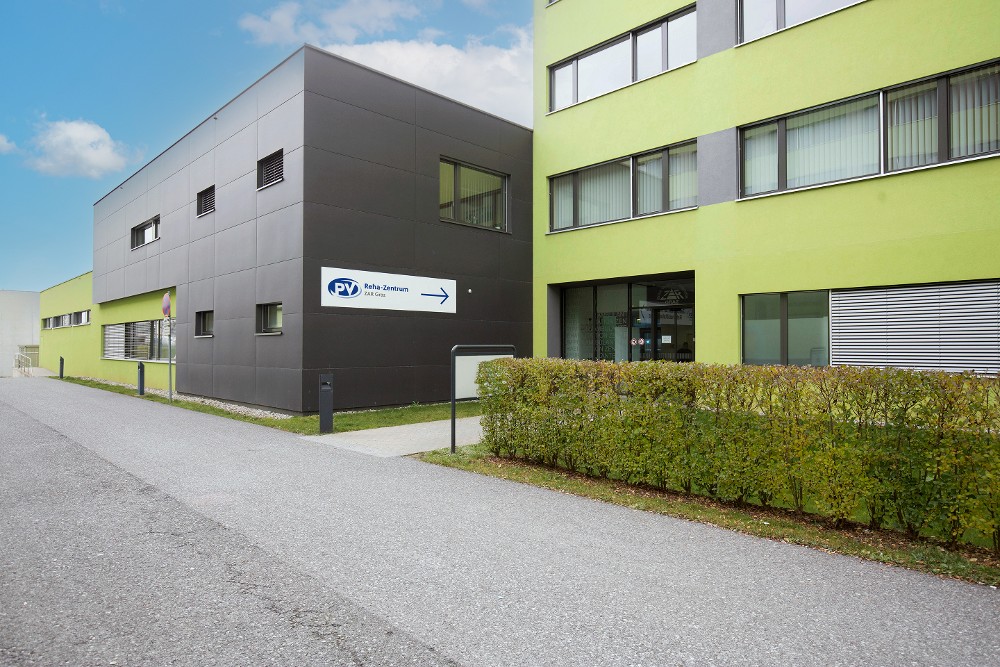 Außenansicht des ambulanten Reha-Zentrums Graz mit Eingangsbereich und PV-Wegweiser