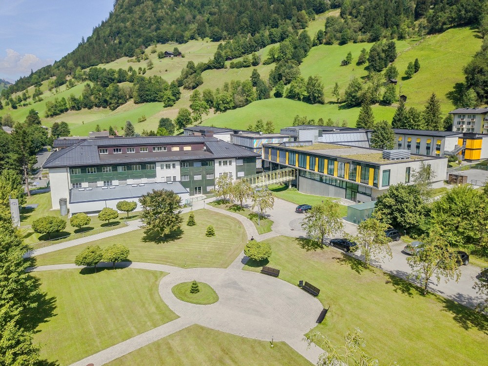 Blick auf das Reha-Zentrum Bad Hofgastein mit Gartenanlage und grünen Hängen im Hintergrund