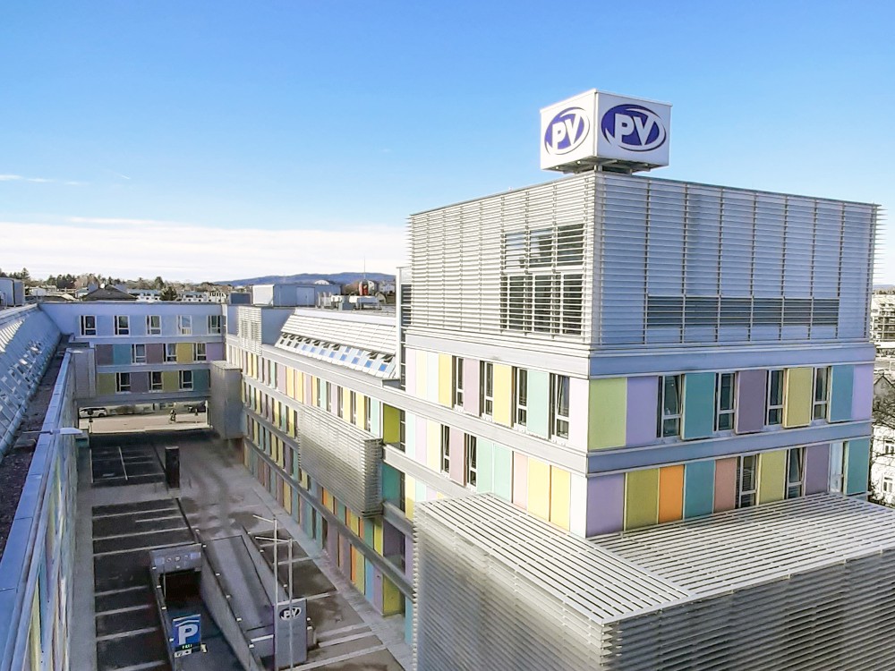 Blick von oben auf die Landesstelle Niederösterreich mit PV-Logo und farbigen Fassadenelementen