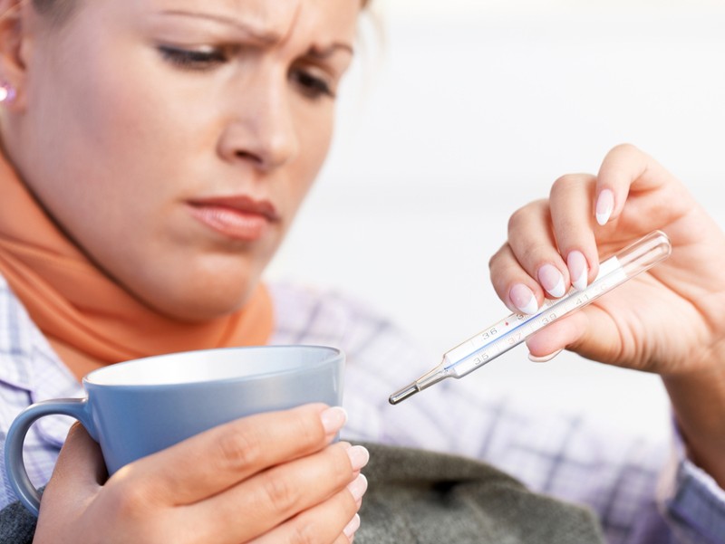 kranke Frau mit Teetasse und Fieberthermometer_Foto: www.shutterstock.com