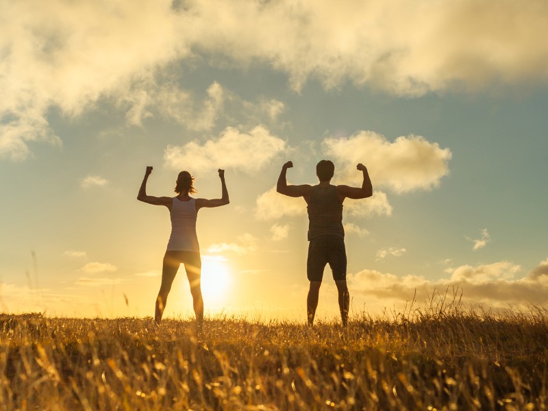 Zwei Personen auf einem Feld im Sonnenuntergang, Foto: © KieferPix - Shutterstock