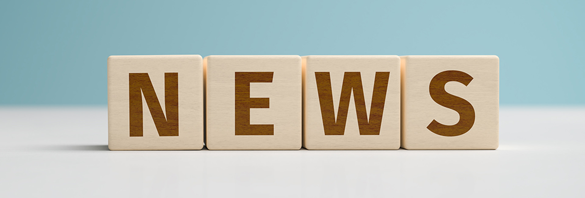Holzwürfel zeigen das Wort News auf blau-weißem Hintergrund