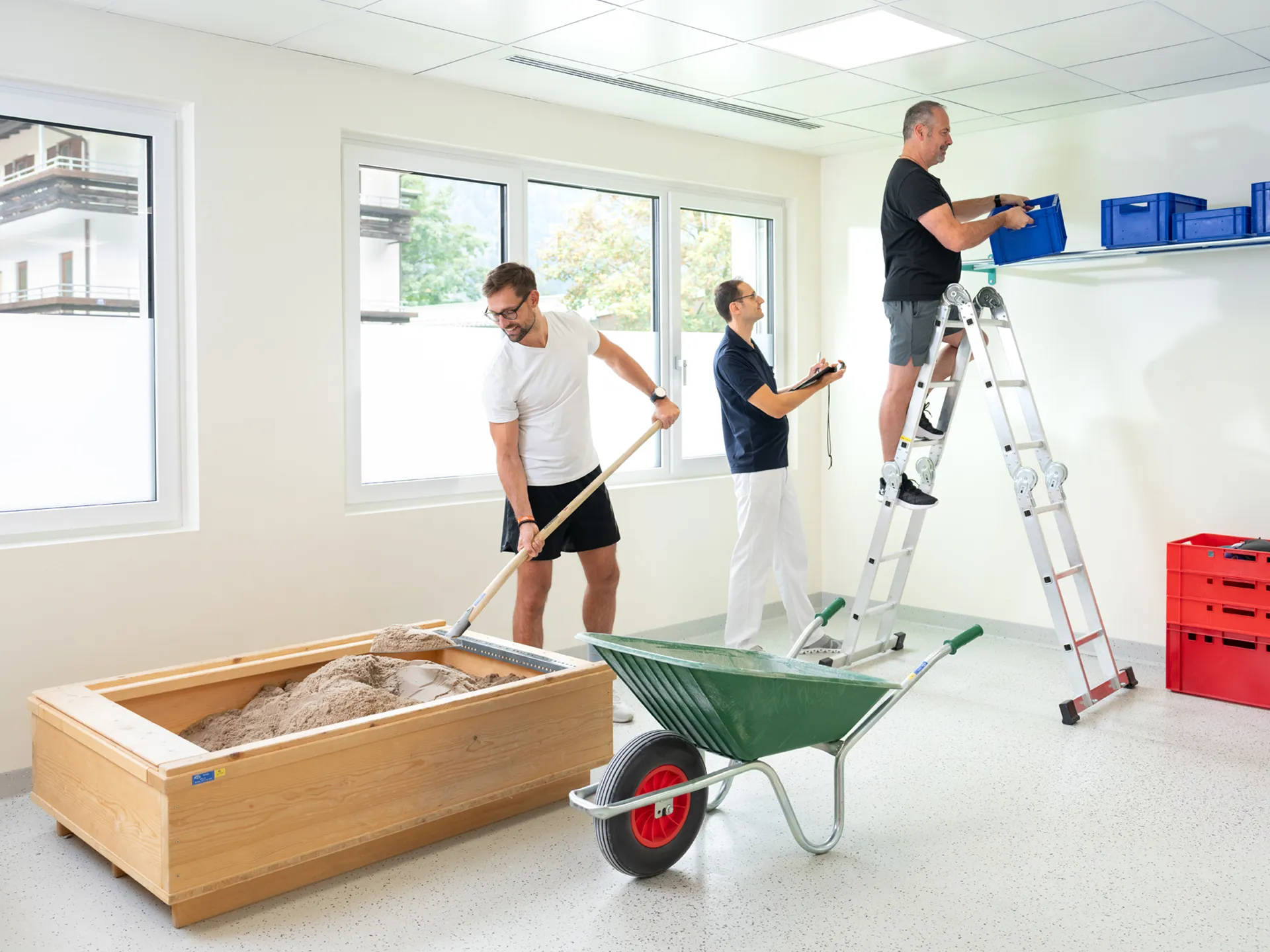 Ein simulierter Baustellen-Arbeitstag mit Schubkarre, Sand, Schaufeln und einer Leiter
