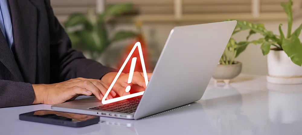 PHP-Sicherheitslücke: Laptop mit Warnschild auf dem ein rotes Rufzeichen zu sehen ist